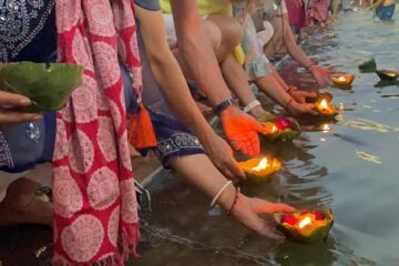 Teilnehmer einer Aarti-Zeremonie am Ganges in Indien setzen Schiffchen mit Kerzen und Blumen ins Wasser.