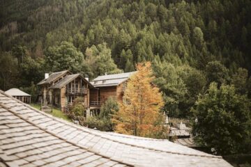 Mehrere Häuser einer Hotelanlage in Südtirol umgeben von dichtem Wald