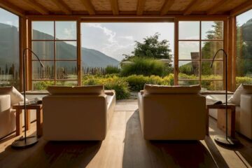 Ausblick aus einem Hotelzimmer in Südtirol, mit Sicht auf Wald, Wiesen und Berge.