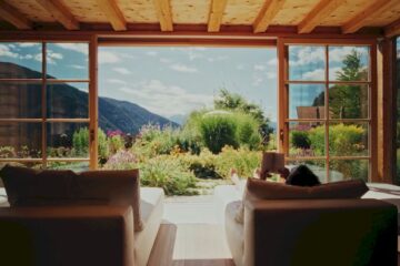 Zimmer mit Ausblick in die Berge und einem bunten Garten