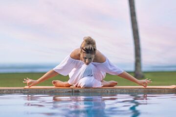 Frau beim Yoga machen am Pool